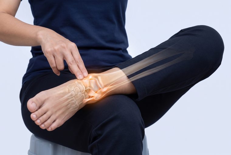 Pressing on the bony bump on the inside of the ankle with two fingertips.