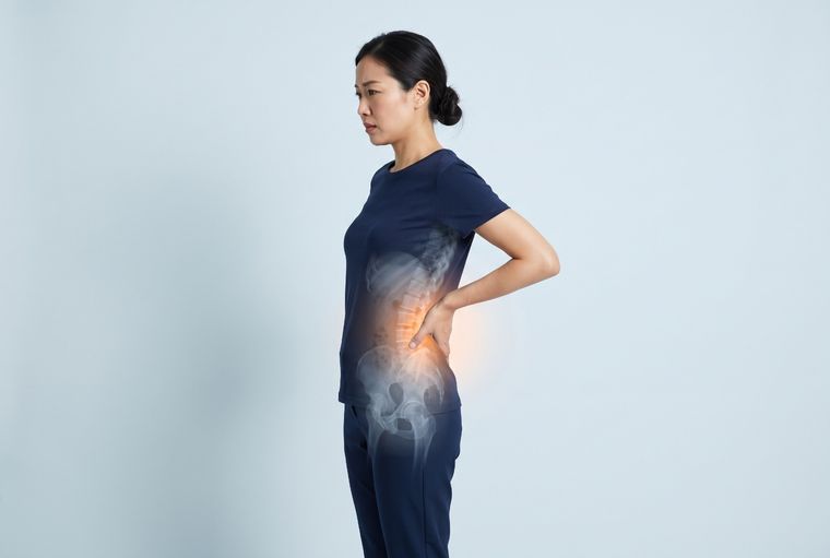 Self-check: standing with a hand on the lower back, noticing whether the pain changes with posture and movement.