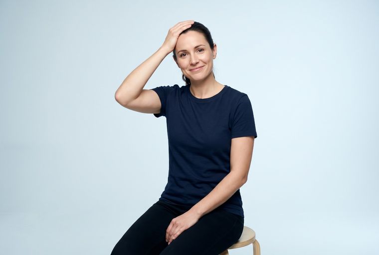 Self-check: sitting with one hand resting on top of the head, a position that may ease arm symptoms coming from the neck.